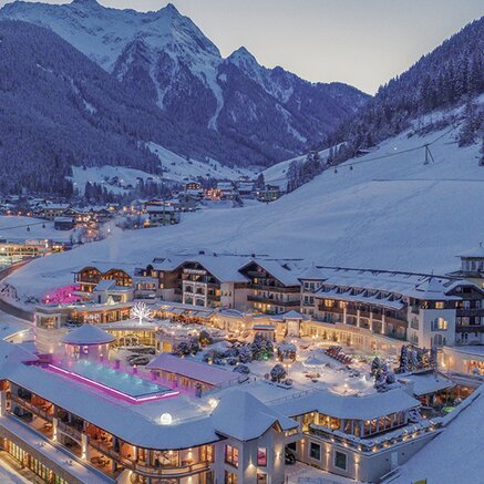 Hotelanlage im Winterort mit schneebedeckten Bergen im Hintergrund