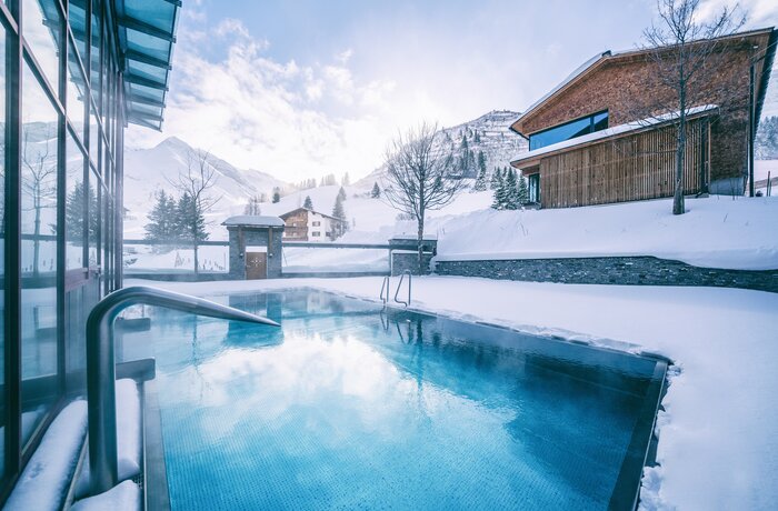 Heated outdoor pool in snowy landscape | Wellnesshotel Warther Hof, Arlberg