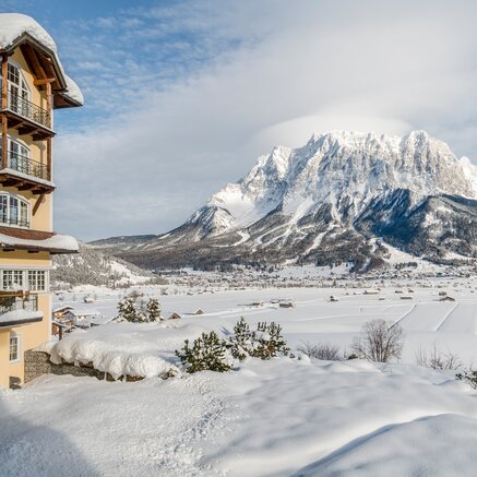 Winterliche Ansicht des Hotel Post vor schneebedeckter Bergkulisse